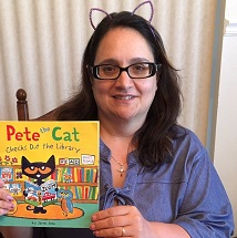 CHildren's Librarin Miss Marie holidng up "Pete the Cat" book