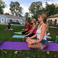 Teens doing yoga on the lawn