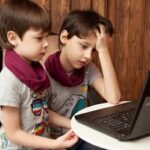 two boys working on a laptop