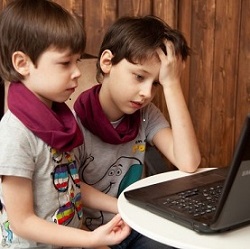 two boys working on a laptop