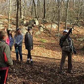 Teens and an adult hiking in woods
