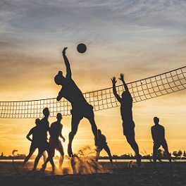 teens playing volleyball on beach