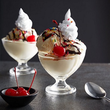 two ice cream sundaes in glass dishes