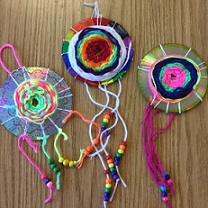 colorful yarn and beads wrapped around recycled CDs