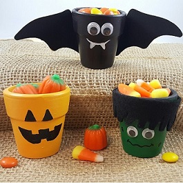 planter pots decorated to look like a pumpkin, bat with wings and Frankenstein