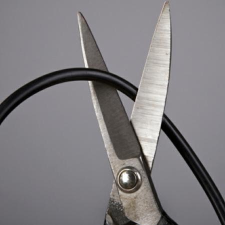 scissors cutting through a cable cord