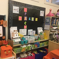 Bulletin Board with "MakerSapce" in block letters, shelves with bins of craft supplies