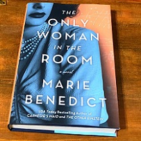 Book with title The Only Woman in the Room, superimposed over image of a woman