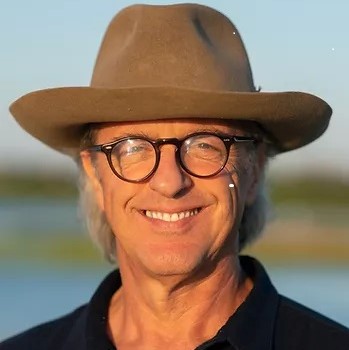 head shot of man with glasses wearing fedora