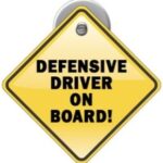 Yellow car sign with words "Defensive Driver on Board"