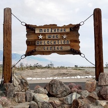 Wooden sign on posts with words Manzanar War Relocation Center