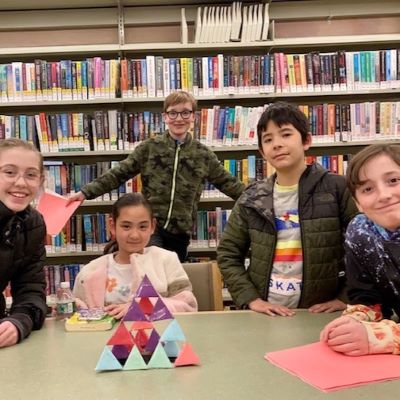 tween boy and girls sitting at a table with a tetrahedron they designed