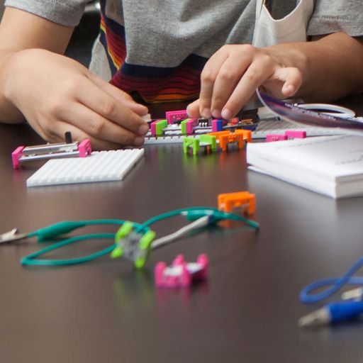 child's hands building with LittleBits engineering parts