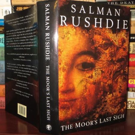 Book standing on table with cover image of woman and title The Moor's Last Sigh, by Salman Rushdie