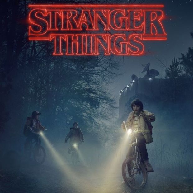 words Stanger Things hovering over picture of 3 boys riding bicycles at night