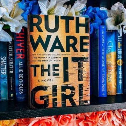 Book Cover that states Ruth Ware The IT GIRL, on a shelf with other books