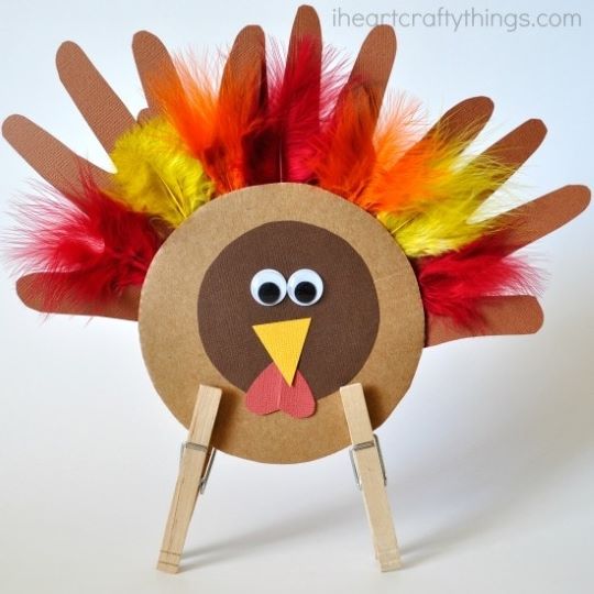 turkey made from construction papers and feathers using clothespins as legs