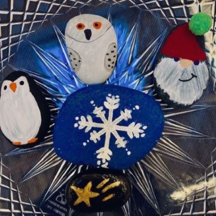 oval river rocks painted with: snowflake, owl, santa clause, penguin, gold star