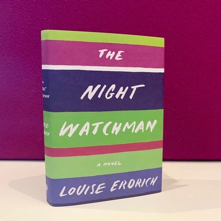 Book cover with colorful horizontal strips containing the words The Night Watchman
