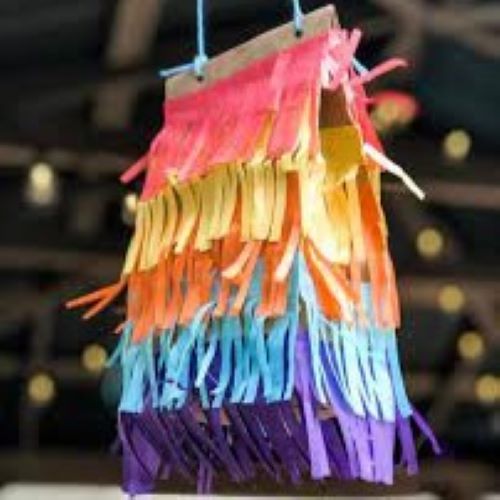 Paper bag covered with colorful paper strips and string tied to top to hang as pinata
