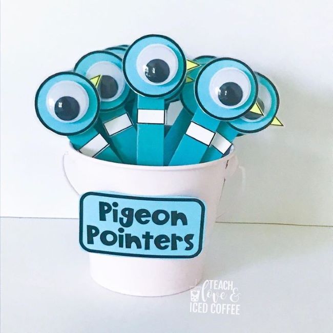 googly eyes on tongue depressors in a cup