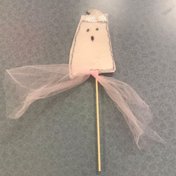 paper ghost mounted on stick , decorated with crown and netting