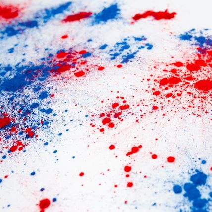 splashes of red and blue paint on a white canvas