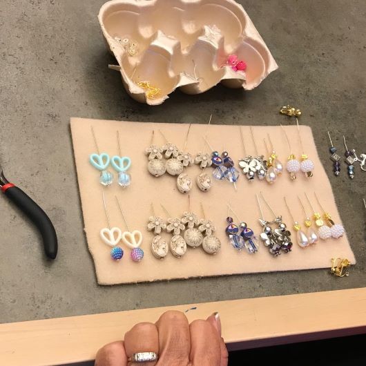 rows of hand designed earrings to be donated