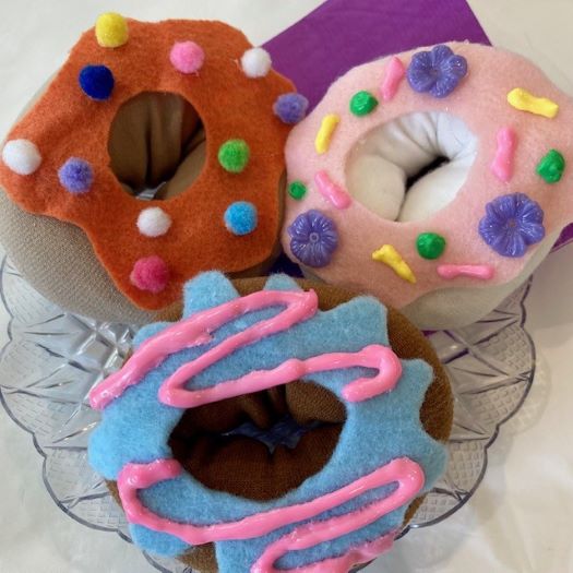 glass plate holding 3 fake "doughnuts" fashioned from socks, felt and decorations
