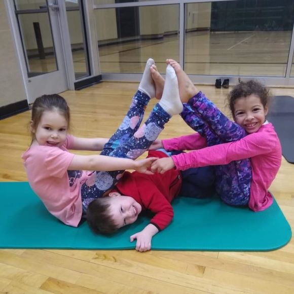 3 small children doing yoga poses
