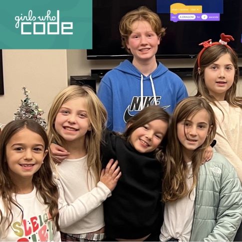 Young girls under a Girls Who Code sign