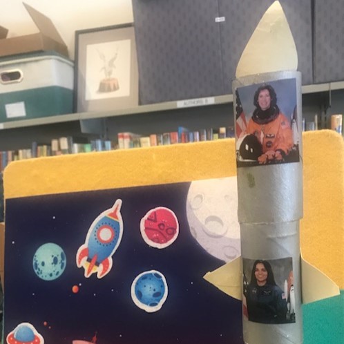 rocket made from paper tubes with images of women astronauts pasted on the side