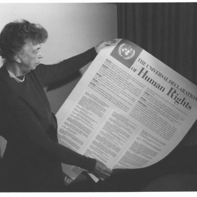 Eleanor Roosevelt holding up a poster titled The Universal Declaration of Human RIghts