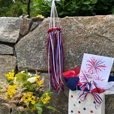 red white and blue wind sock, gift bag and vase of flowers