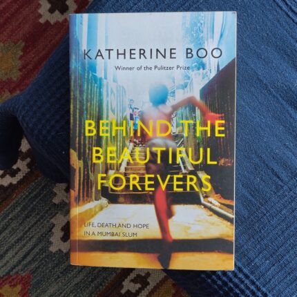 book jacket with words Behind the Beautiful Forevers, over image of boy running up outdoor street steps