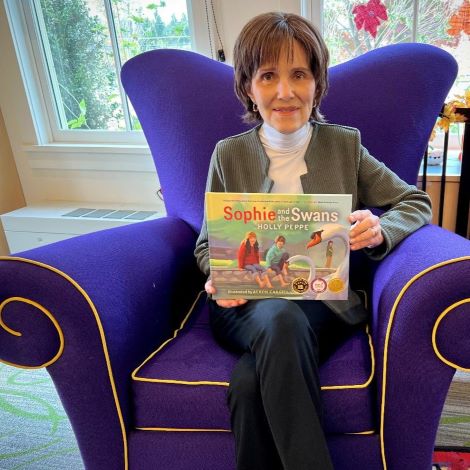 woman sitting in purple eaay chair holding picture book