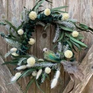 Holiday wreath made from artificial flowers and a bird