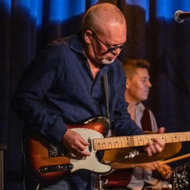 man playing guitar in nightclub