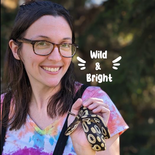 woman with brown hair and glasses holding a snake