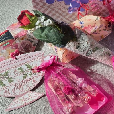 pink gauze bag filled with decorated clips alongside artificial rose wrapped in lace