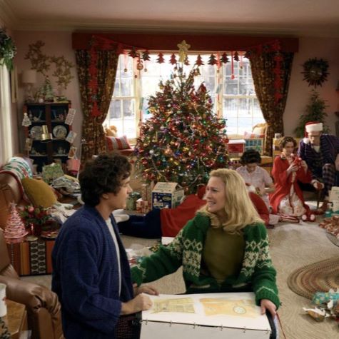 man and woman opening gifts in front of Christmas tree