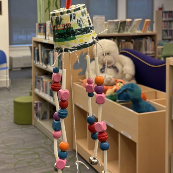 wind chime made from empty yogurt cup, wooden beads and straws
