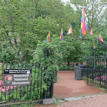 Photograph of gateway to park inside metal fence with plaque naming Stonewall National Monument