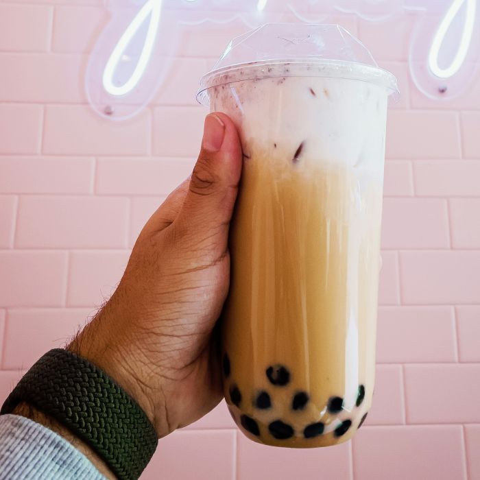 hand holding up a carry-out container of Boba Tea