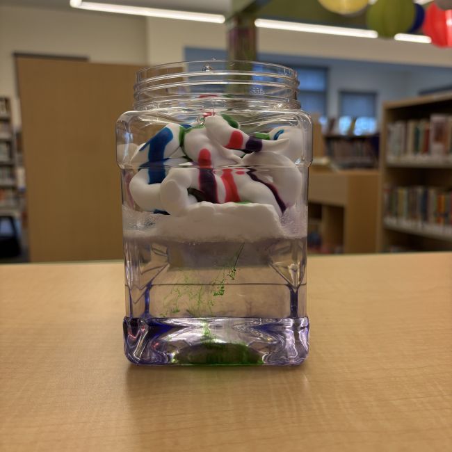 glass jar filled with colored shaving cream floating in water