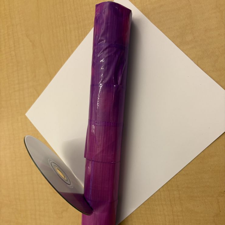 tube of purple cellophane with cd sliced into the top