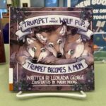 Book cover titled Trumpet Becomes a Mom, underneath illustration of three wolf pups