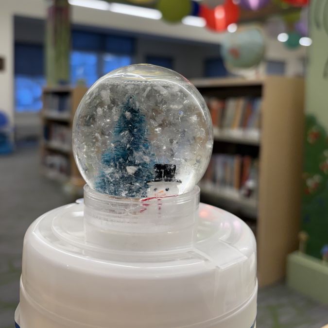 snow globe containing a fir tree and snowman