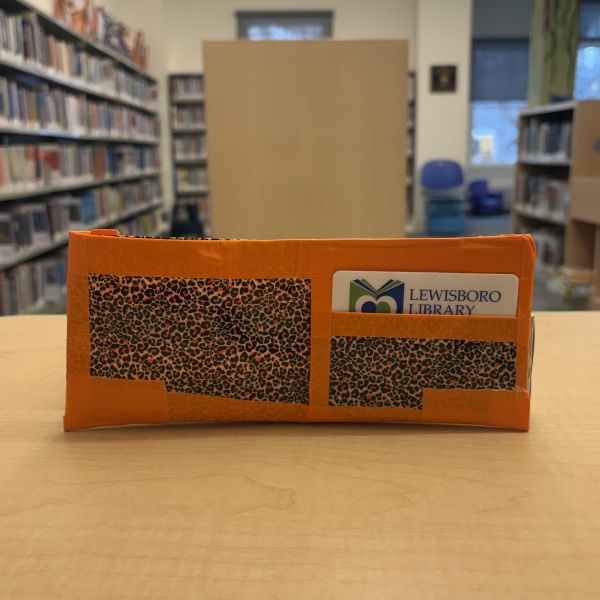 A children's wallet made from orange and animal print duct tape.