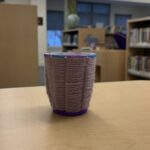 woven cup made from yarn woven through paper cup